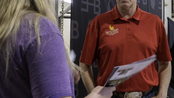 A person in a red shirt holding a piece of paper